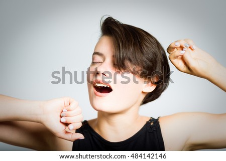 short-haired woman stretching after sleep, portrait, isolated on gray background