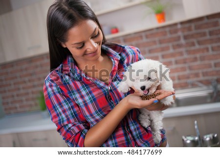 Picture of beautiful young girl at kitchen with dog