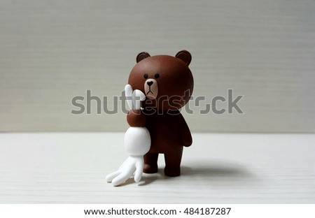 Bear figure and rabbit on wood background