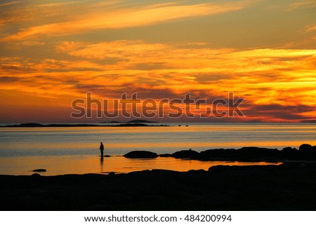 Silhouette of fishermen with yellow and orange sunset.