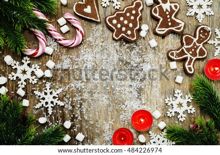 wood background with Christmas tree, candy, cookies, marshmallow and snowflakes. toning. selective focus