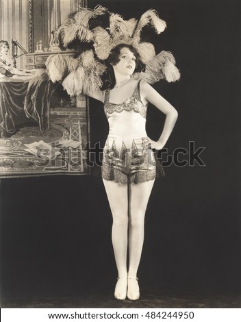 Showgirl wearing feathered headdress Royalty-Free Stock Photo #484244950