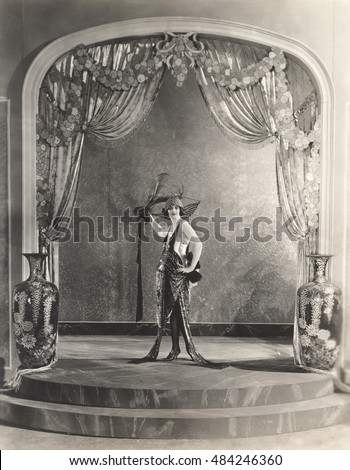 Showgirl posing under archway Royalty-Free Stock Photo #484246360