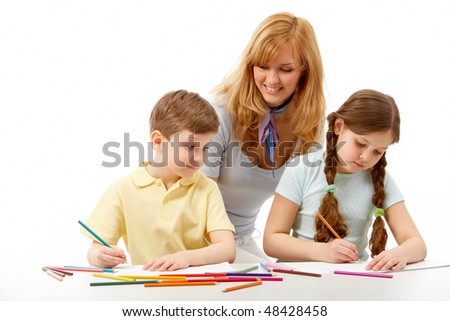 Portrait of children drawing pictures and teacher standing near