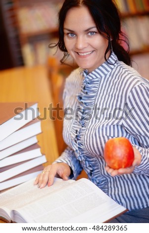 photo of Portrait of happy smiling young brunette student girl with apple