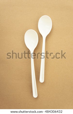Twin spoons on brown background ,White spoon, The device is one of the cooking container. in eating