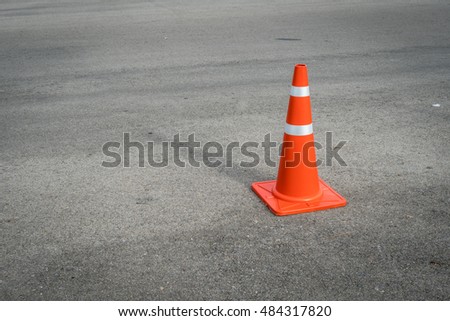 Plastic orange cone on the asphalt road