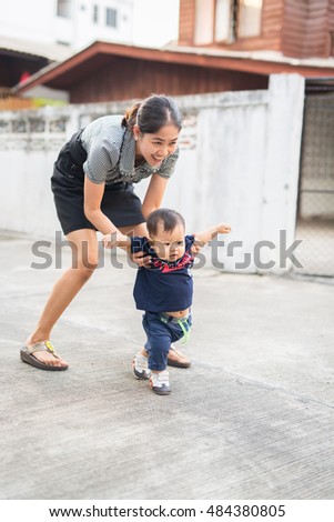 mother is playing with her son. they are always happy when they stay together. mother is the first teacher of child. in this picture, mother is teaching her son to play football.