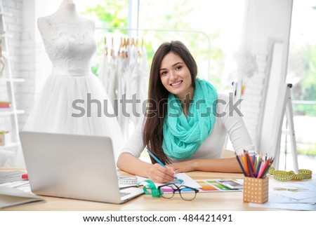 Pretty young dress designer at workplace