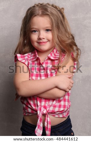 Baby with folded arms. Close up. Gray background