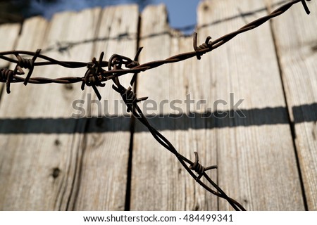 Barbed wire on a wooden fence