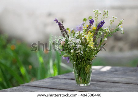 Vase with wild flowers on table, soft focus photo shallow depth of field