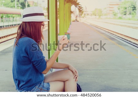 Beautiful girl drinking coffee on the railway station,beautiful woman waiting for train travel