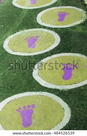 The colorful footprints on the concrete walk way.