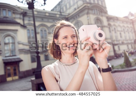 Pretty young woman using camera