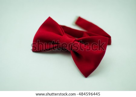 A stylish and well-designed red bow-tie on a white background; isolated
