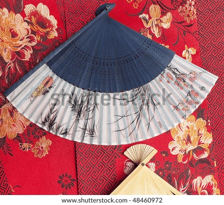 Chinese fan on red textile background