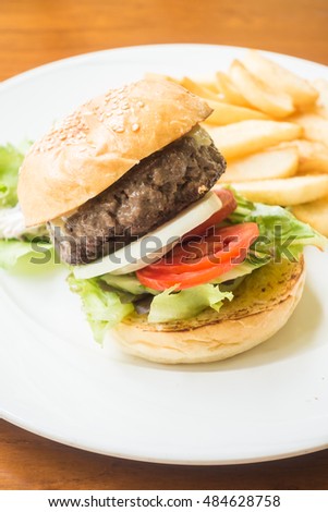 Beef hamburger with french fries in white plate - Junk food style