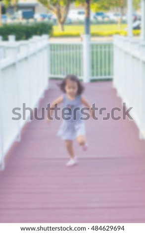a blurred picture of little girl running on white wood bridge in park, filtered color tone