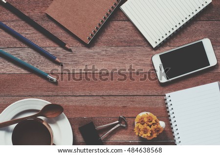 Office stuff and it gadgets display on top view business desk with copy space at text of picture. Filter effect vintage tone film. Creative table, modern project. Dark style still life.