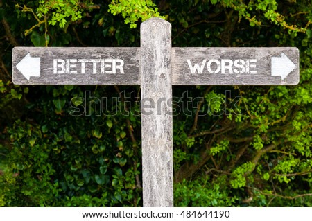 Wooden signpost with two opposite arrows over green leaves background. BETTER versus WORSE directional signs, Choice concept image