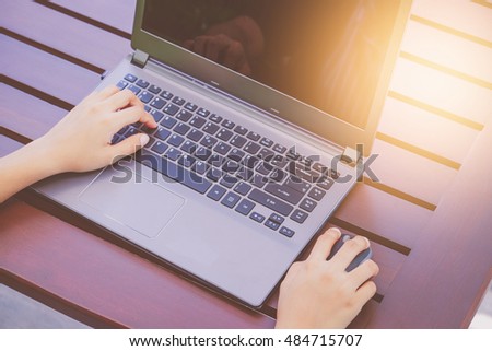 hands working on laptop with vintage tone