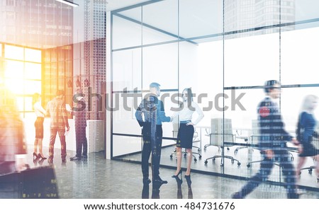 Busy office interior. Group of colleagues are standing near reception counter. Pair of people shaking hands. Concept of business environment. Toned image