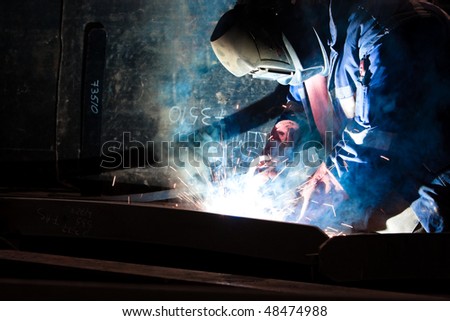 worker welding steel in factory