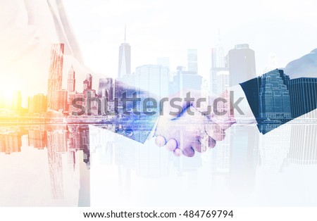 Two businessmen shaking hands. Large city at the background. Concept of business meeting.  Toned image. Double exposure