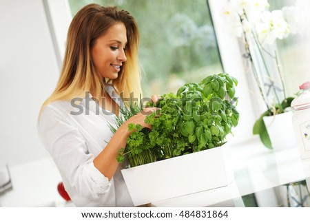 Picture of young woman with herbs in the kitchen