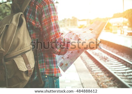 Young tourist with a beard holding a map   travel concept