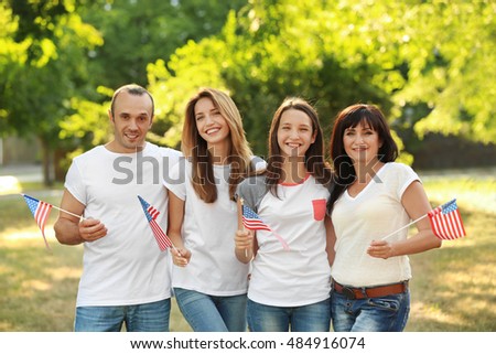 Modern family with USA flags outdoors