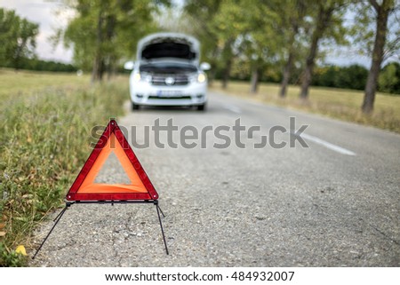 Closeup of red triangle to warn the other road users about a damaged car