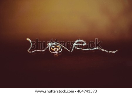 Silver word Love lies on the blurred brown background