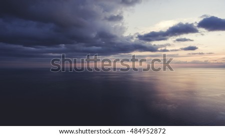 Aerial photo from flying drone of an amazing scenery of calm Indian Ocean and evening Twilight. Beautiful sky with sunset rays reflected in calm sea water. Wonderful nature wallpaper