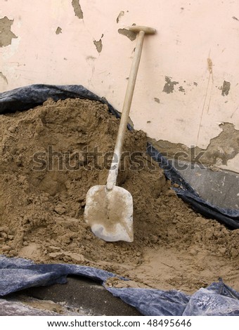 Vertical picture of dirty shovel put in the heap of concrete