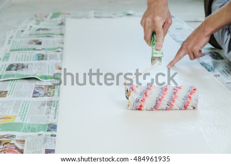 Worker pasting wallpapers. He put glue using a roller. Royalty-Free Stock Photo #484961935