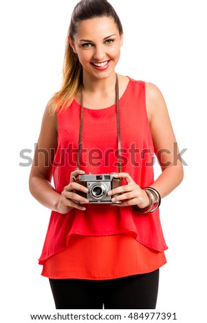 Beautiful woman taking a picture with a vintage camera isolated on a gray background