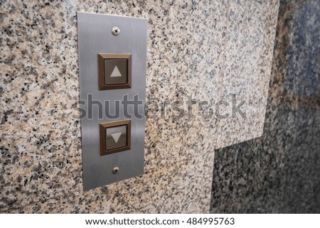 Metal Switch panel for calling an elevator in a building with space on the right of photo
