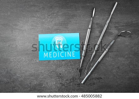 Medical concept. Business card and dentist tools on gray background