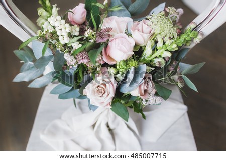 Bridal bouquet on vintage white wooden chair