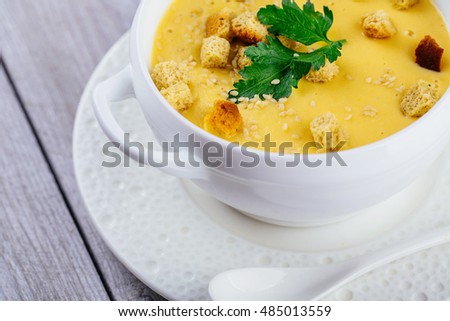 pumpkin cream soup on wooden background