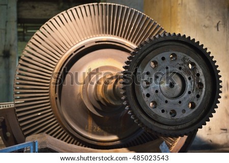 Detailed Picture of the rotor of steam turbine for coal electric power plant or power station on the support. Picture of the main shaft, propellers, blades and gearwheel.