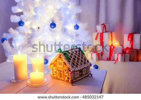 Christmas table in white with homemade gingerbread cottage