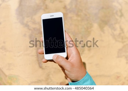 Closeup on business man hand showing smartphone with world map for social and internet projects. Gps navigation searching mockup technology
