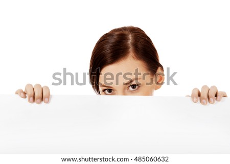 Beautiful student woman hiding her face behind blank banner