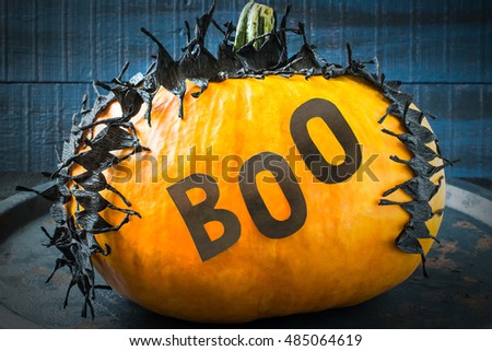 Idea homemade decorating for Halloween. Application: barbed tape made of black crepe paper and word boo on pumpkin. The original design in the style of Halloween. Tinted photo