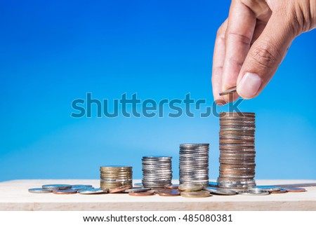 Male hand putting coin money like stack growing business on blue sky background. Finance and Money concept, Hope of investor concept