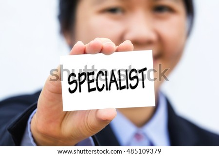 Businesswoman holding card with SPECIALIST message.