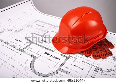 Construction helmet and protective gloves, construction of the building layout, building drawing on paper, protective clothing